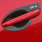 Coquille de poignée effet carbone avec logo CX-5 sur une Mazda CX-5 rouge