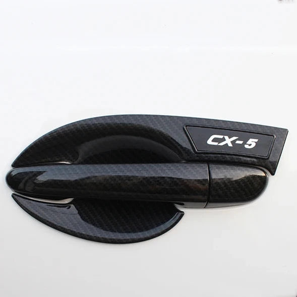 Coquille de poignée noire avec logo CX-5 sur une porte de Mazda CX-5